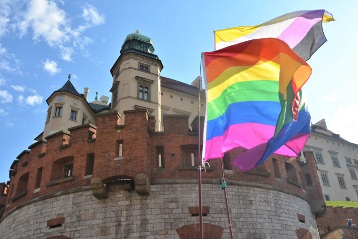 Drapeau arc-en-ciel flottant devant un bâtiment public lors d'une marche pour l'égalité