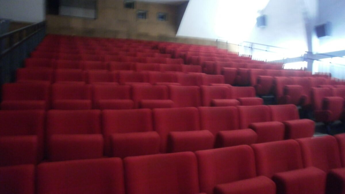 Rangées de fauteuils rouges dans une salle de cinéma vide