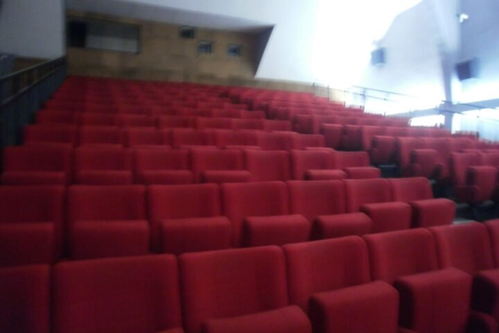 Rangées de fauteuils rouges dans une salle de cinéma vide