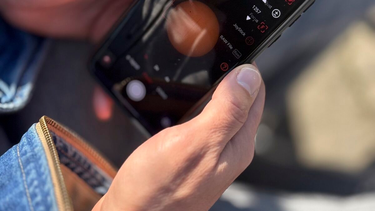 Gros plan sur une main tenant un smartphone allumé