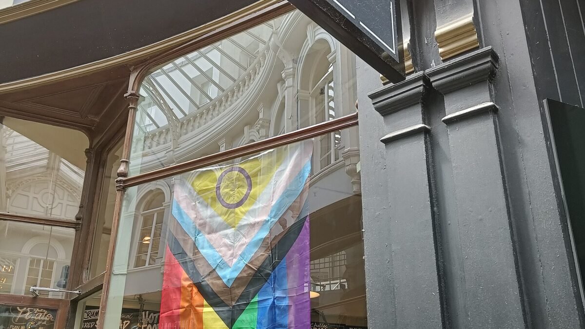 Drapeau Progress Pride incluant le symbole intersexe, accroché dans une rue de Cardiff