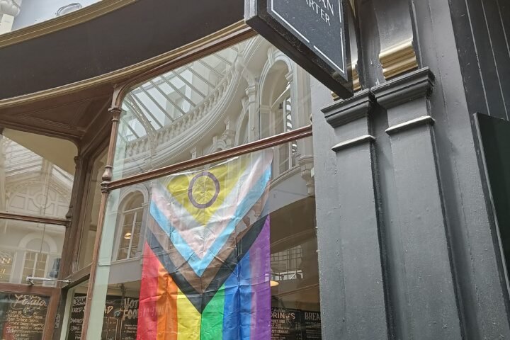 Drapeau Progress Pride incluant le symbole intersexe, accroché dans une rue de Cardiff
