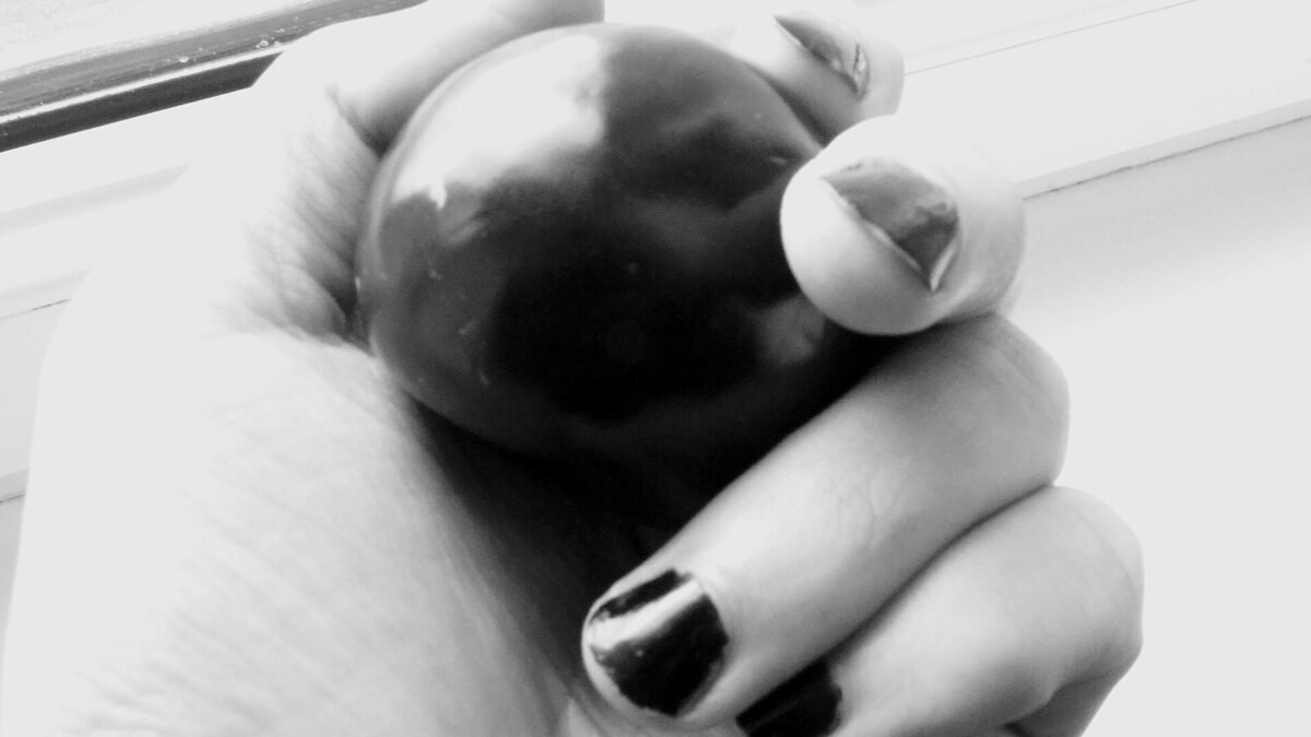 Main portant du vernis à ongles noir, en noir et blanc
