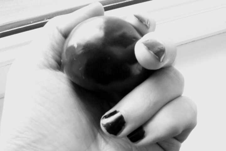 Main portant du vernis à ongles noir, en noir et blanc